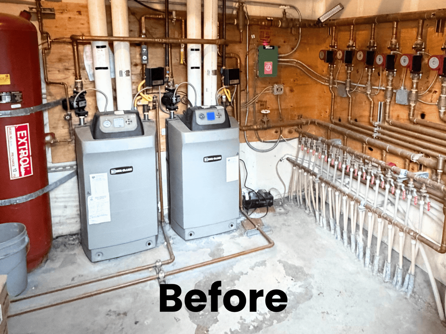 Before: Basement utility area featuring two grey boilers, a red expansion tank, and complex copper piping systems covering the walls.