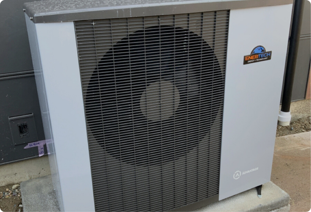 Modern, light grey outdoor Air-to-water heat pump unit featuring a prominent circular black fan grill, a colorful brand logo, and compact design.