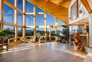 Spacious room with high ceilings and a mostly glass wall with a view