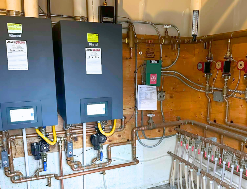 Dual Rinnai Boilers on wall of a commercial building with pumps on the wall