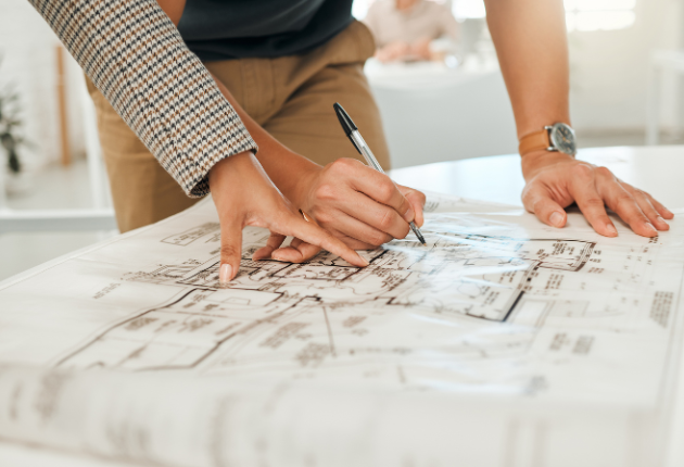 CLose up on contractor and architect looking over home plans