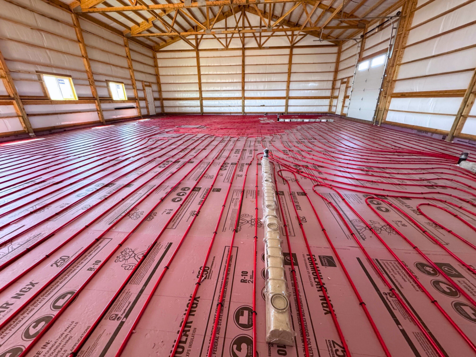 Pole barn with tubing laid out in one direction to the end