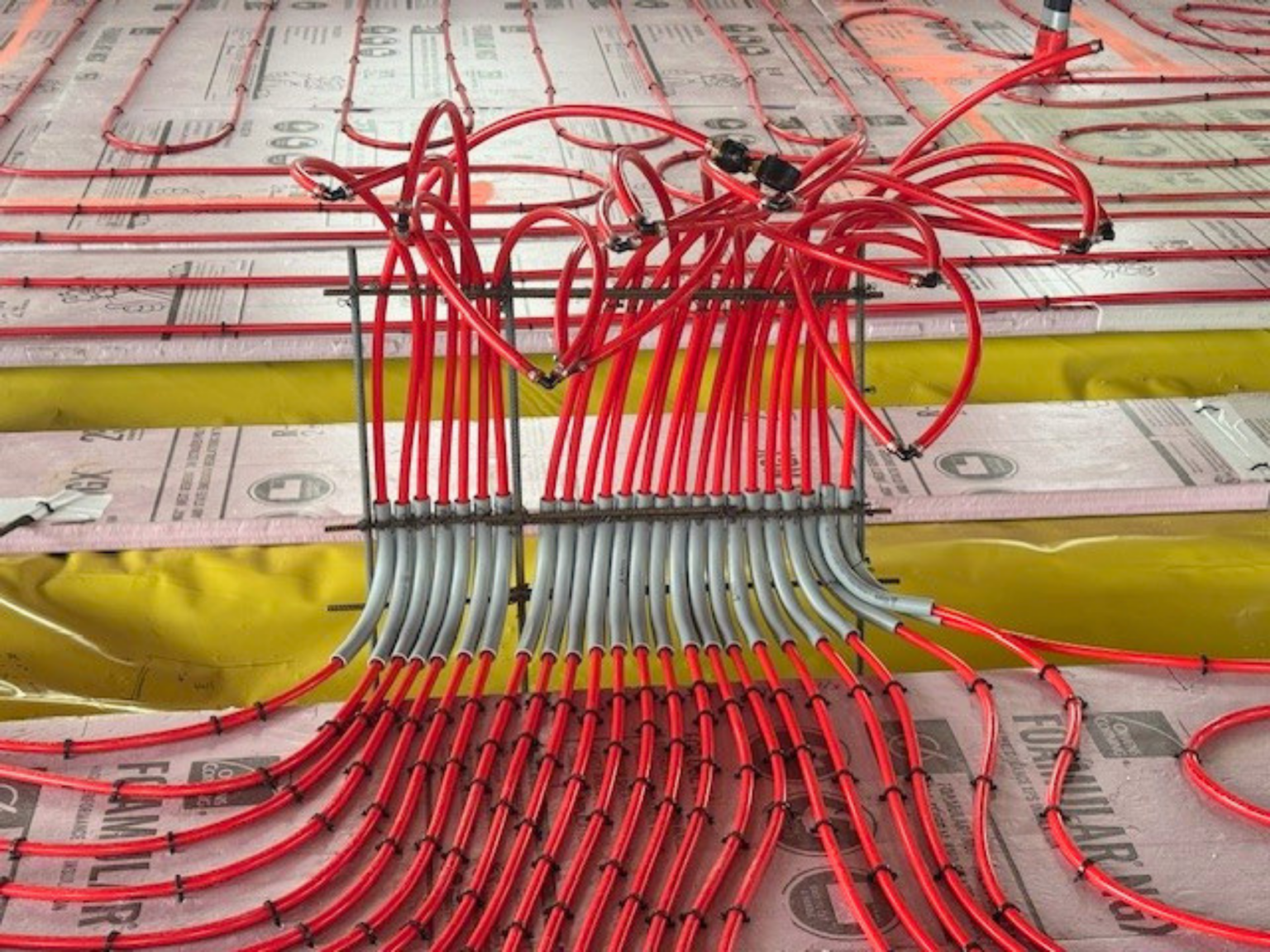 Pole barn Manifold: Red PEX tubing sticking up out of ground