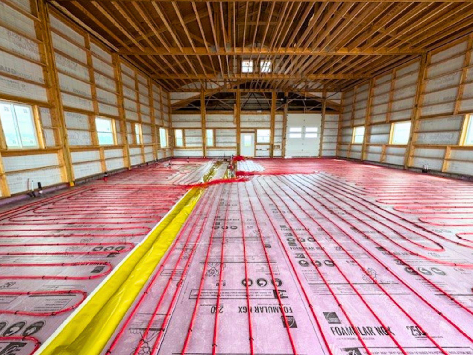 Pole barn with tubing laid out in one direction to the end