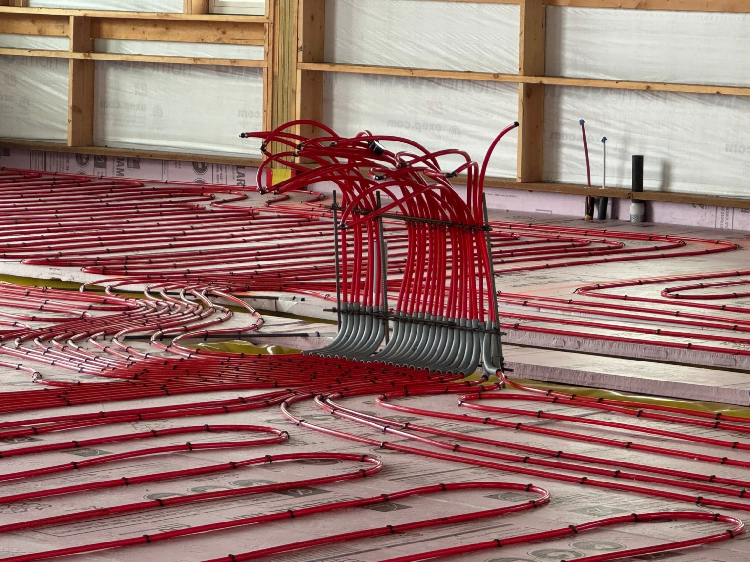Pole barn Manifold: Red PEX tubing sticking up out of ground