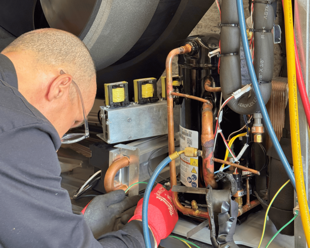 Janes Radiant technician working on Enertech Air-to-Water heat pump.