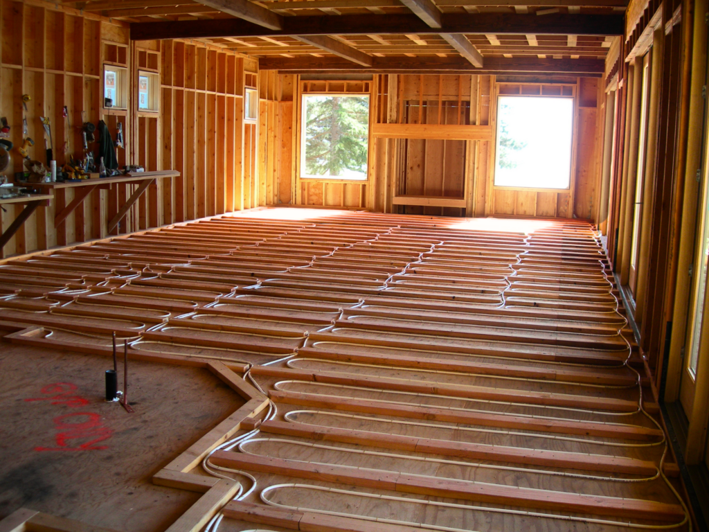 Radiant tubing set in between furring strips on wooden subfloor.