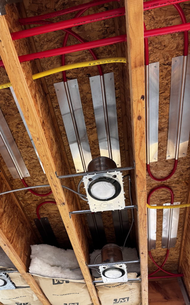 Tuibing stables to sub-floor from below, showing lighting fixtures and insulation.