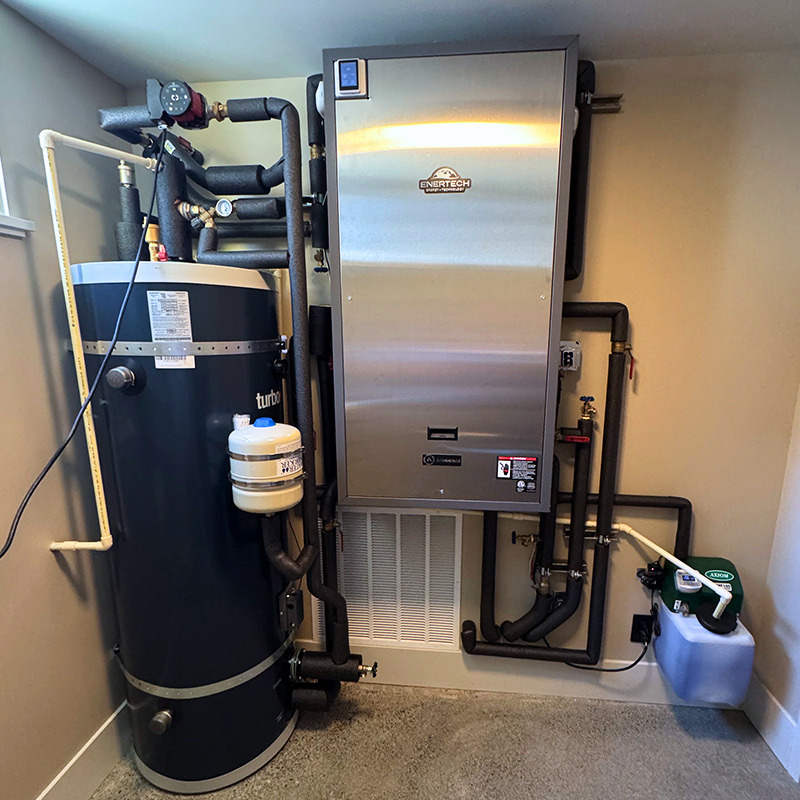Indoor Air to water set up in mechanical room with hot water tank for domestic hot water