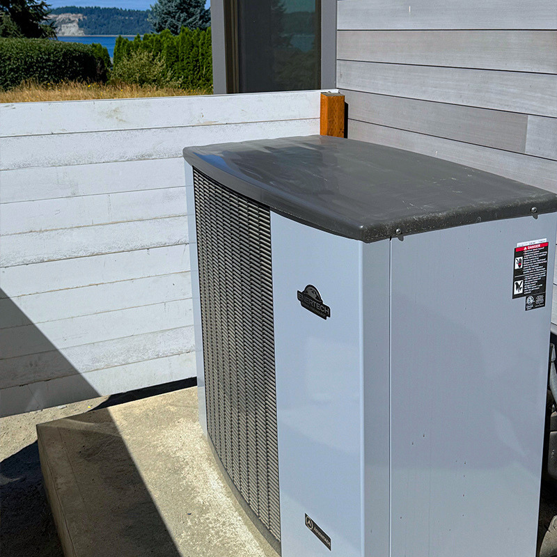Outdoor Air to water heat pump in its own hide-away beside home on Whidbey Island