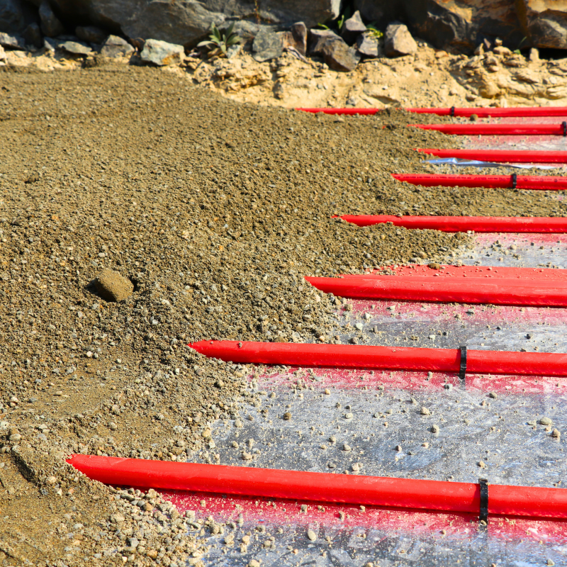 PEX tubing for heated driveway staples into foam with 4 inches of sand being set on top before asphalt is poured
