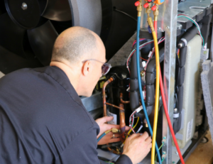 Repair technician working on an air to water heat pump for a customer on Vashon Island, Wa