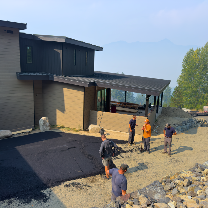 Asphalt driveway being poured and smoothed by workers for a heated driveway