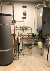 Boiler and hot water tank set up for a home with heating and domestic hot water needs.
