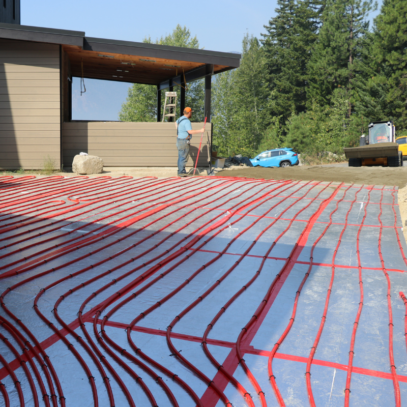 Sand is being layered on tubing for a heated driveway