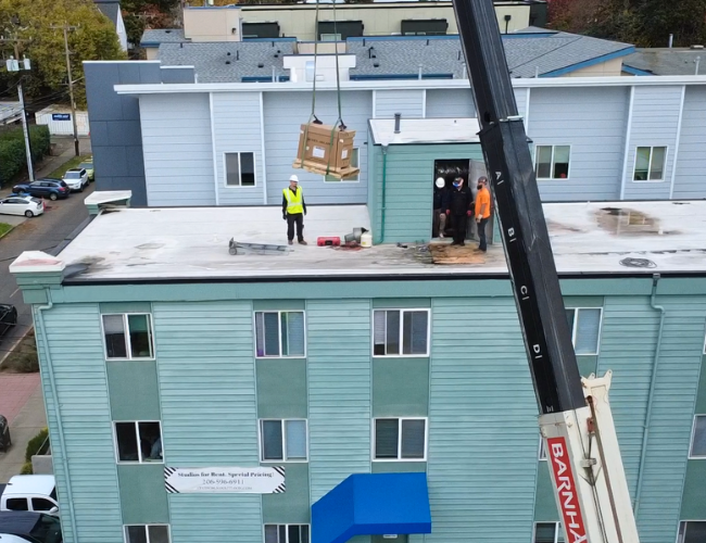 New Weil-McLain boiler landing on rooftop safely to be installed in mechanical room