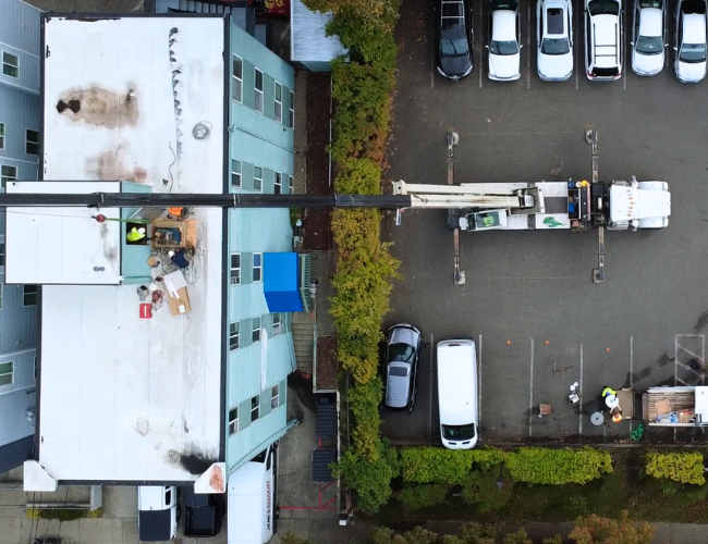 Decommissioned cast-iton boiler being removed from rooftop